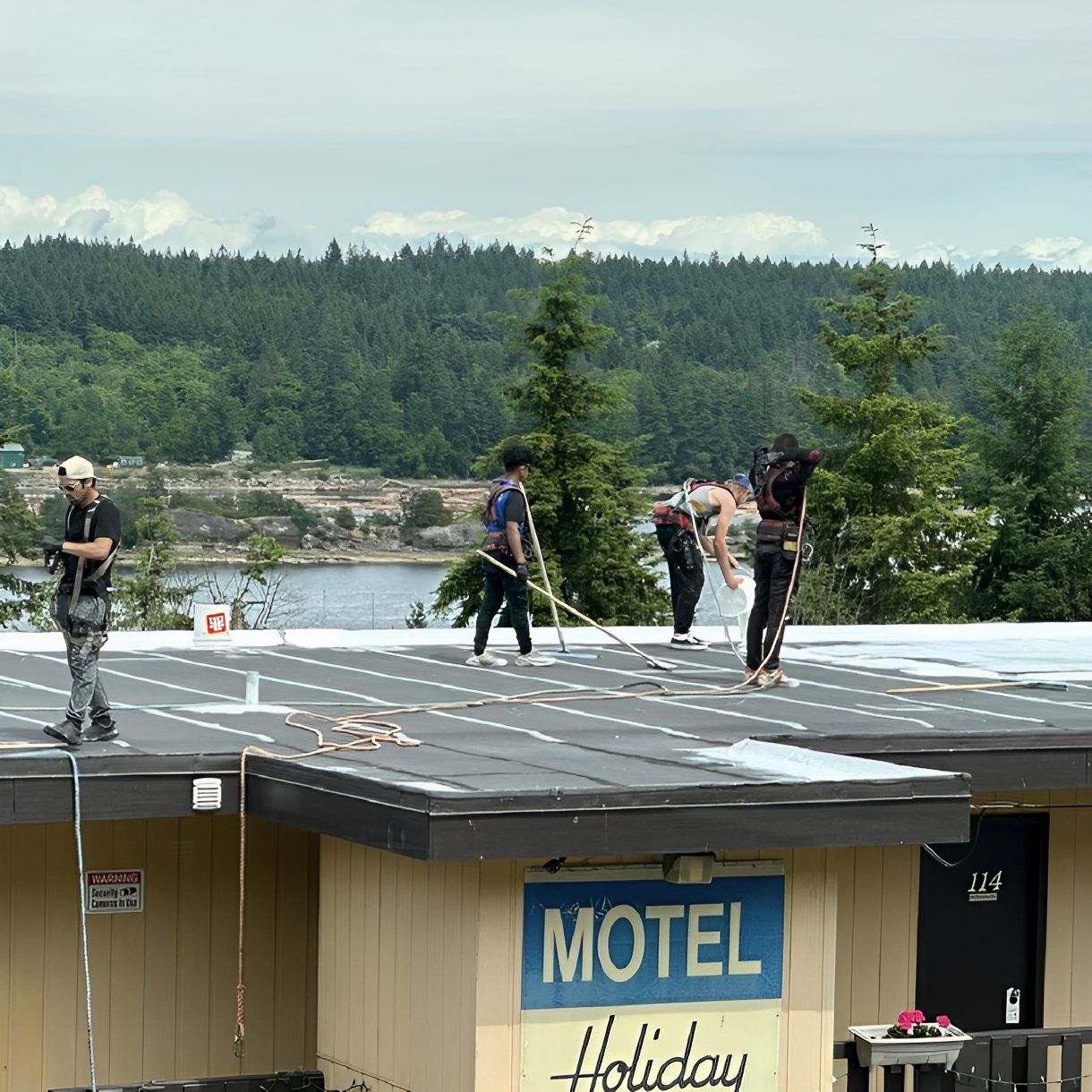 Roofers working on a motel rooftop.