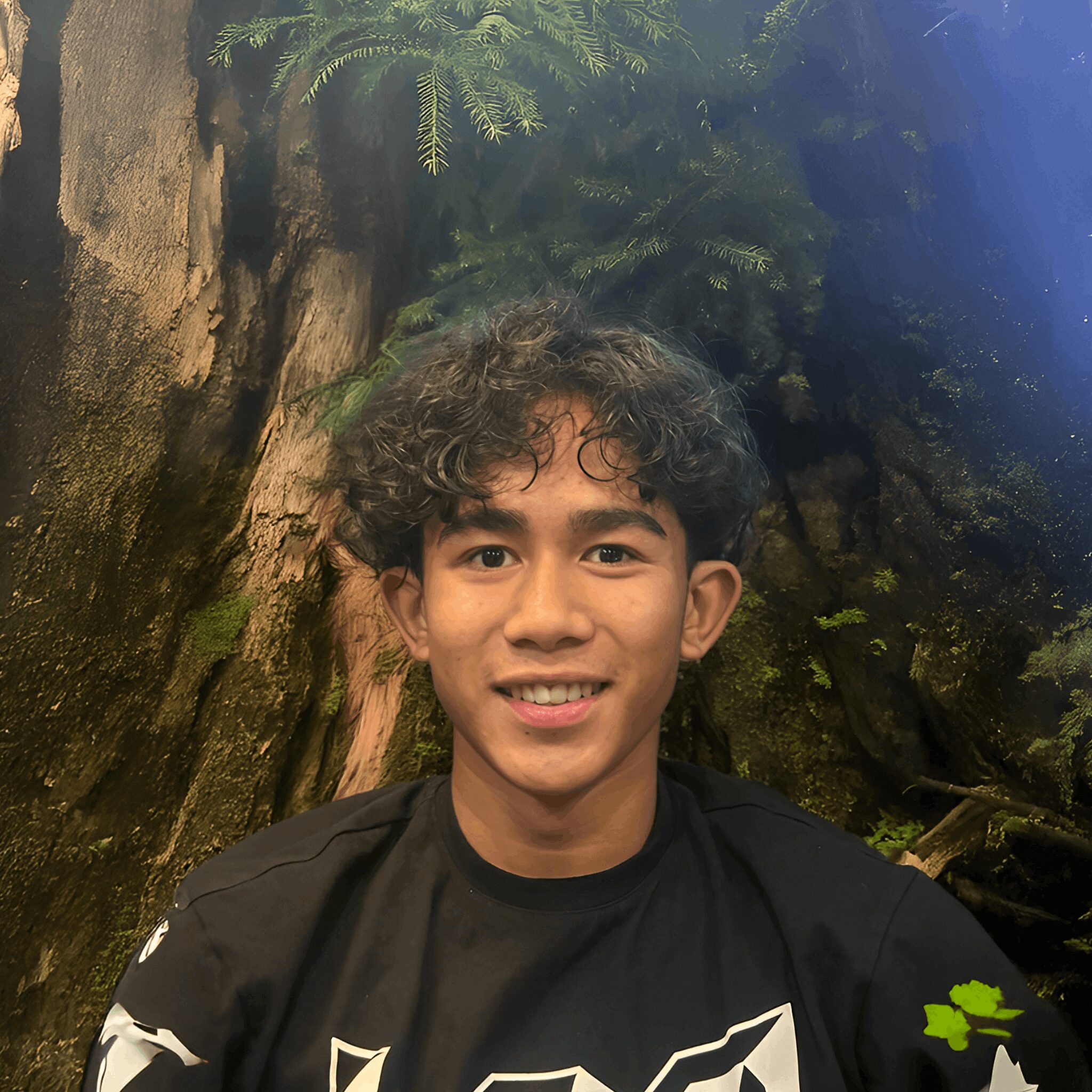 Smiling young person with curly hair.