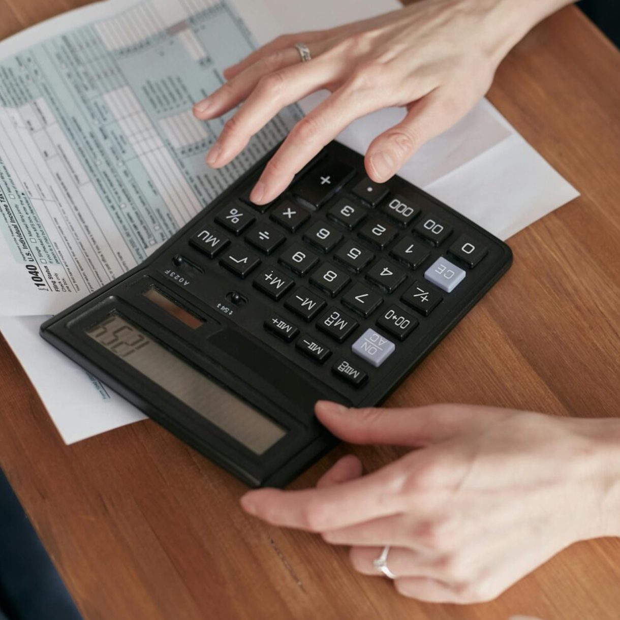 A person is using a calculator to check their taxes.