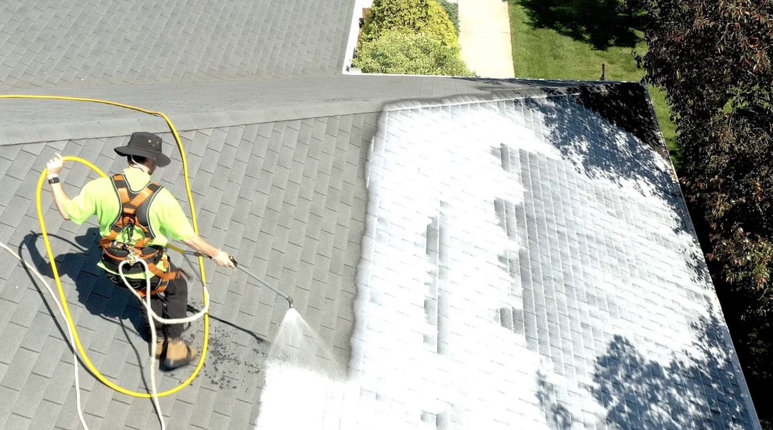 A person is washing the sidewalk with a hose.