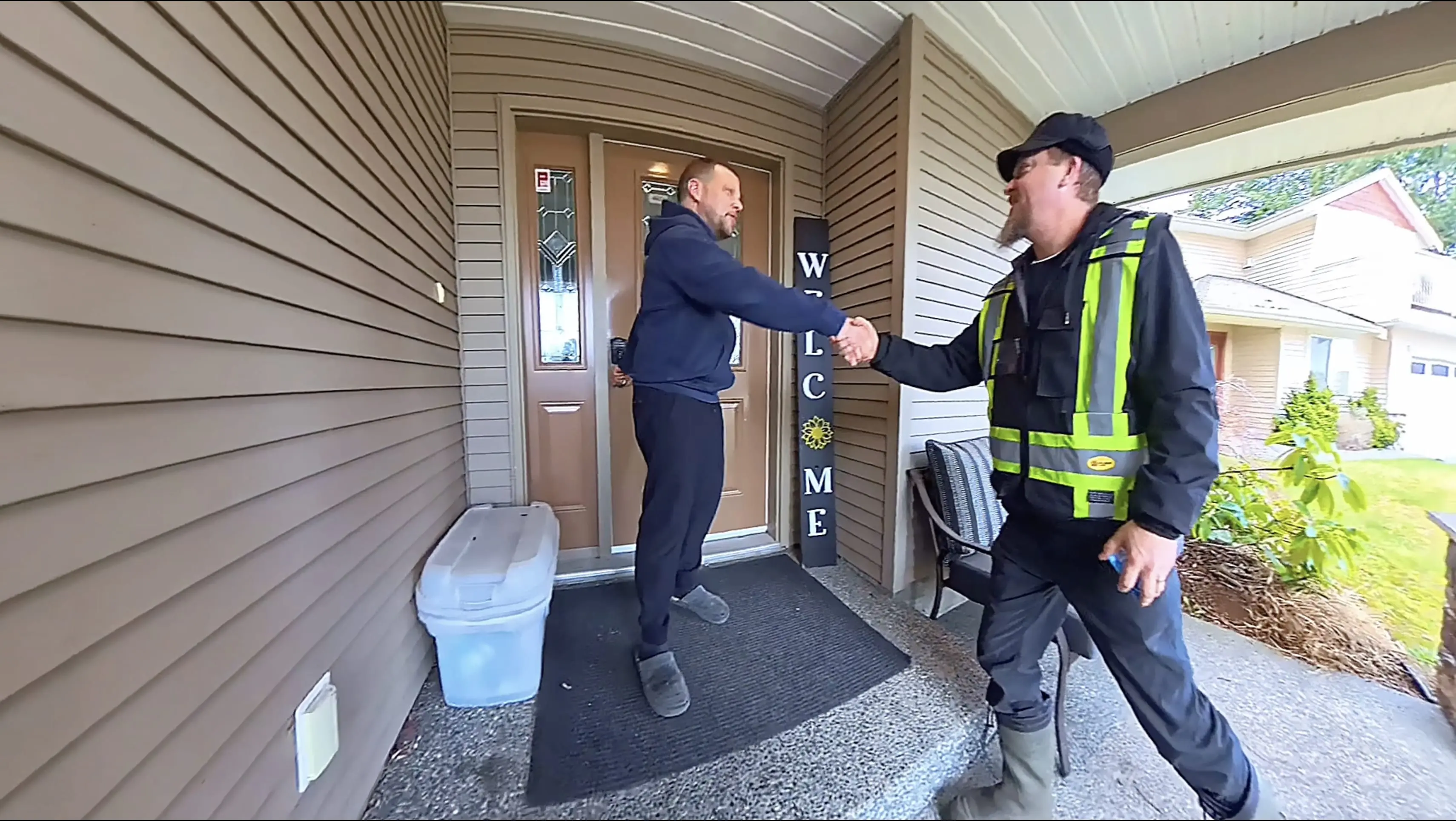 A man shaking hands with another man outside.