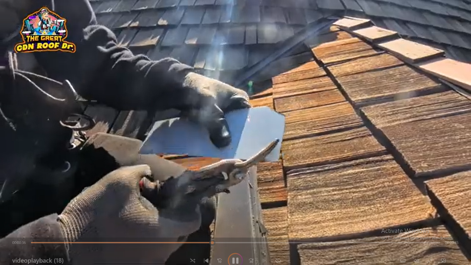 A person holding a pair of scissors and cutting the roof.
